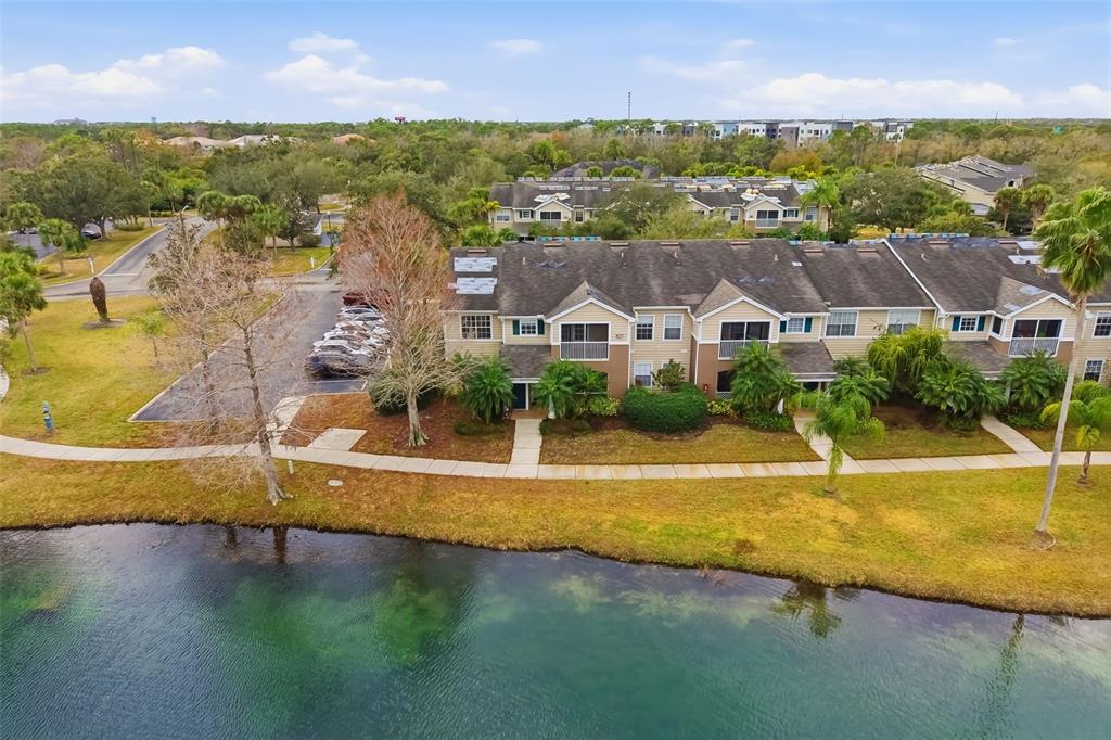 an aerial view of residential houses with outdoor space and lake view