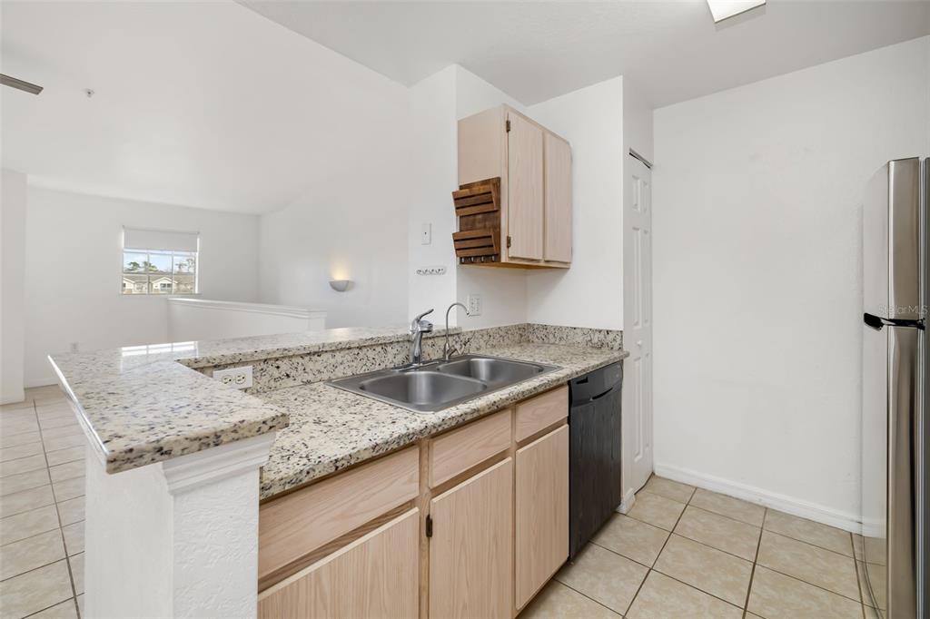 8933 Manor Loop, Unit 205 Lakewood Ranch, FL 34202 - Photo 17 of 76 a kitchen with stainless steel appliances granite countertop a sink and a refrigerator