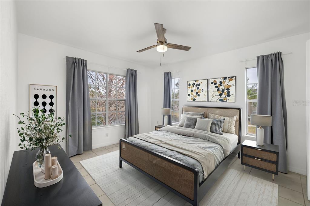 8933 Manor Loop, Unit 205 Lakewood Ranch, FL 34202 - Photo 18 of 76 a bedroom with a large bed and a chandelier