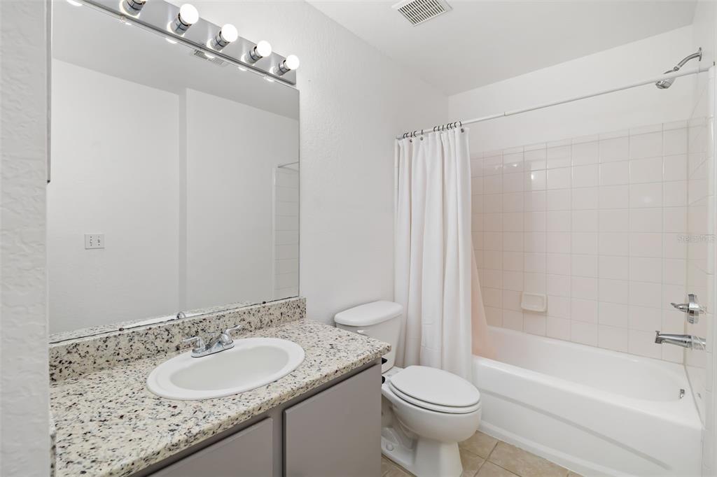 8933 Manor Loop, Unit 205 Lakewood Ranch, FL 34202 - Photo 31 of 76 a bathroom with a granite countertop sink toilet and shower