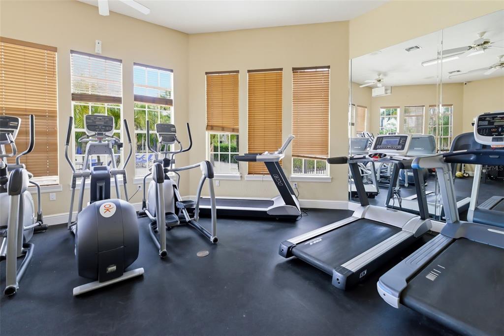 8933 Manor Loop, Unit 205 Lakewood Ranch, FL 34202 - Photo 62 of 76 a living room with furniture gym equipment and large windows