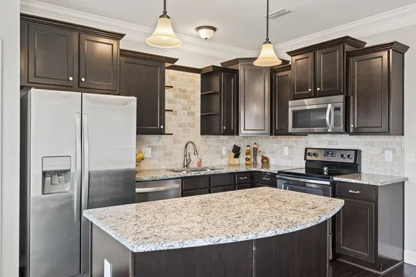 a kitchen with stainless steel appliances granite countertop a sink stove and refrigerator