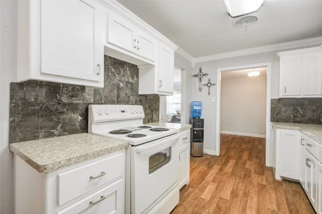 a kitchen with a stove and white cabinets