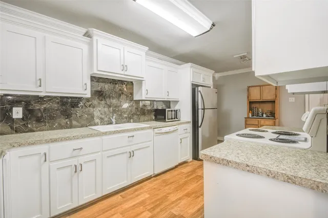 a kitchen with granite countertop a sink stove and refrigerator