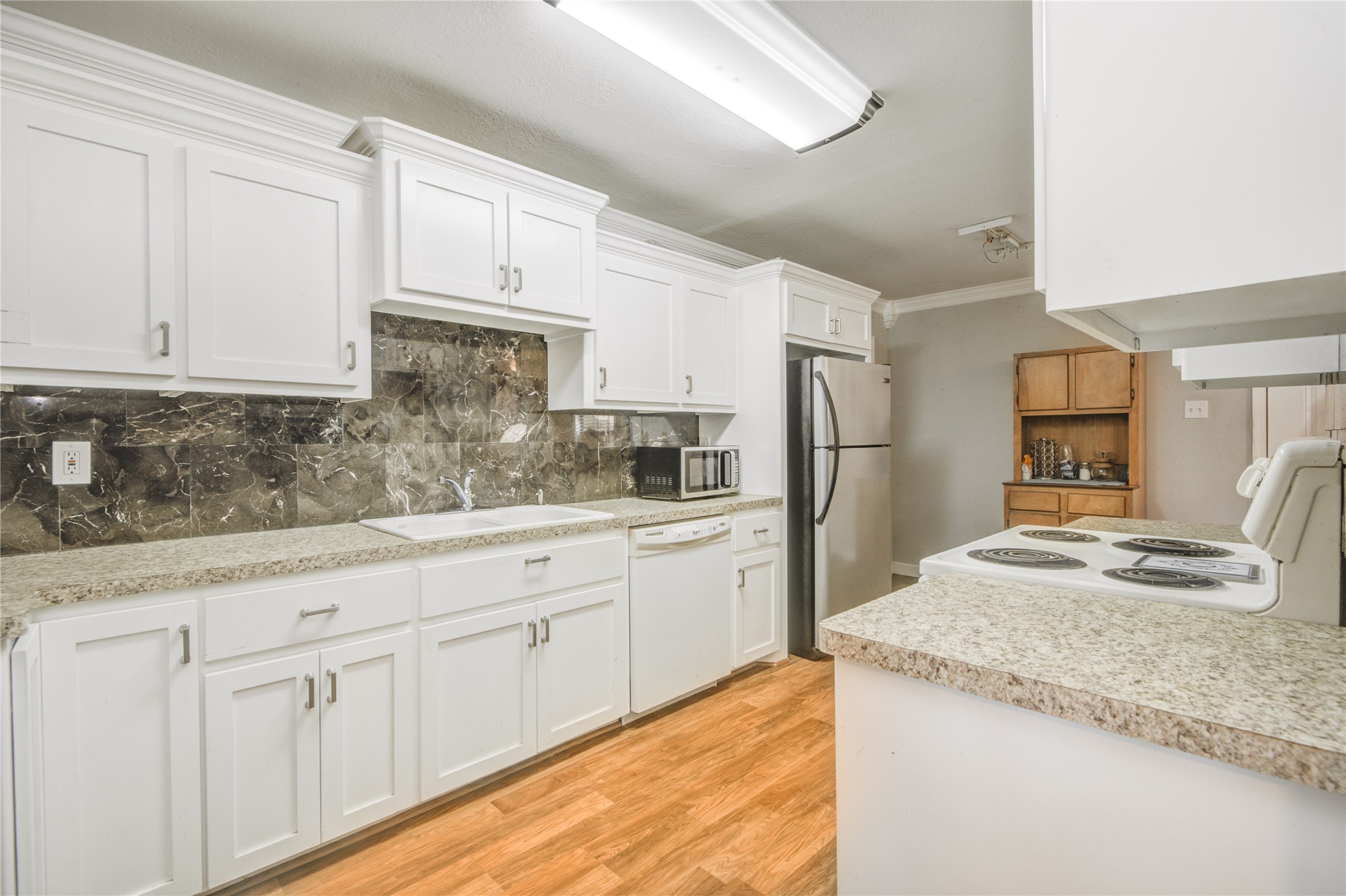 513 Farrer Street Angleton, TX 77515 - Photo 16 of 32 a kitchen with granite countertop a sink stove and refrigerator