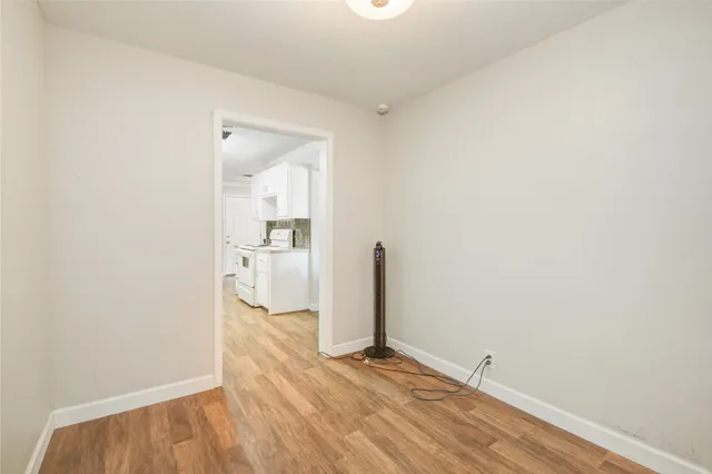 a view of a room with wooden floor and a bathroom