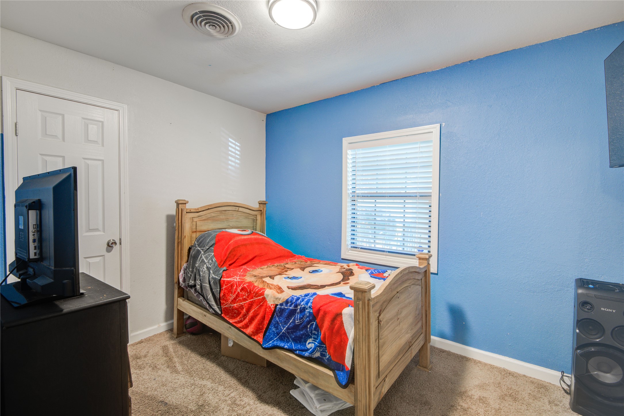 513 Farrer Street Angleton, TX 77515 - Photo 24 of 32 a bedroom with a bed and a tv