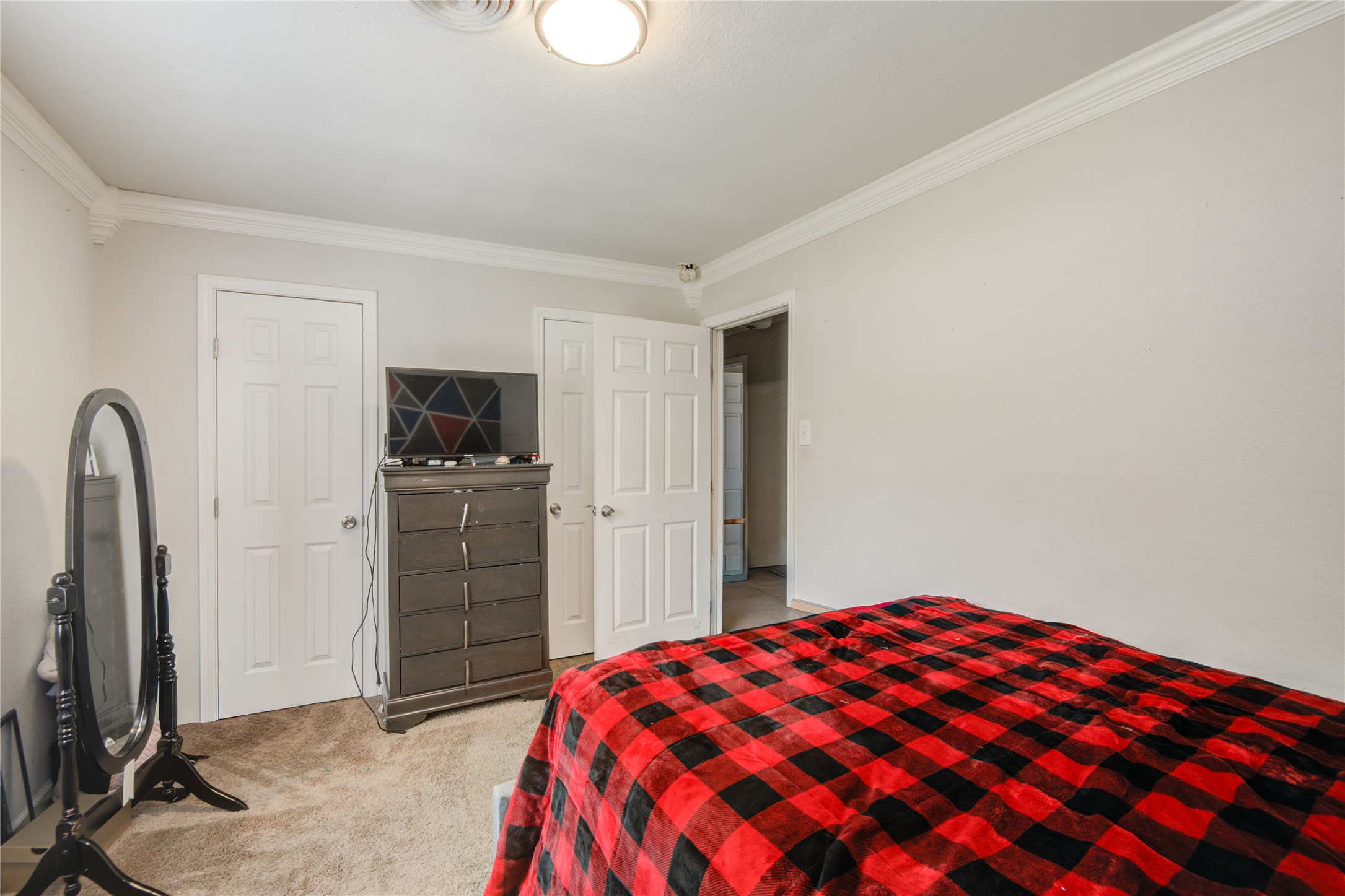 513 Farrer Street Angleton, TX 77515 - Photo 28 of 32 a bedroom with a bed and a flat tv screen on dresser