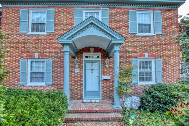 a front view of a house with plants