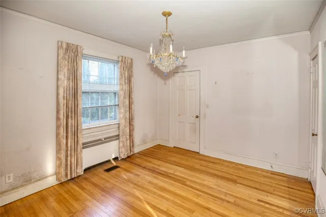 a view of a big room with wooden floor and windows