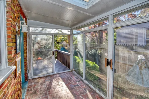 a view of a brick house with a large window and wooden fence