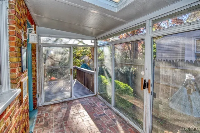 a view of a brick house with a large window and wooden fence