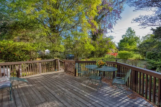 a balcony with wooden floor table and chairs