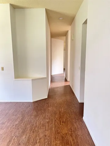 a view of a hallway with wooden floor