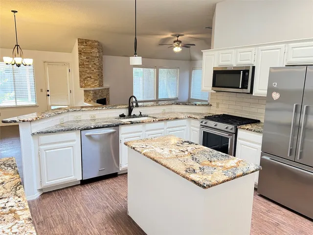 a kitchen with a sink stove and microwave