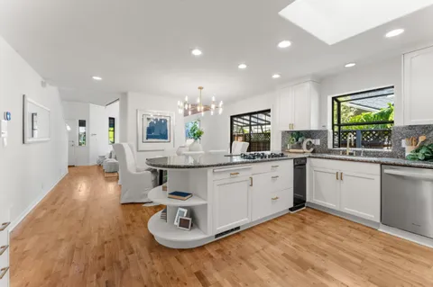 a kitchen with stainless steel appliances granite countertop a sink stove and cabinets