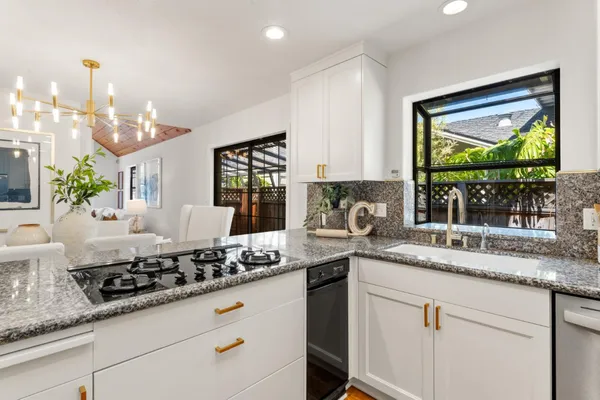 a kitchen with stainless steel appliances granite countertop a sink stove and cabinets