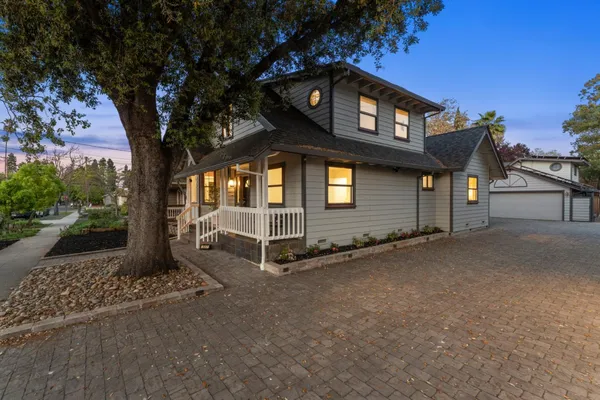 a view of a wooden house with a large window and palm tree