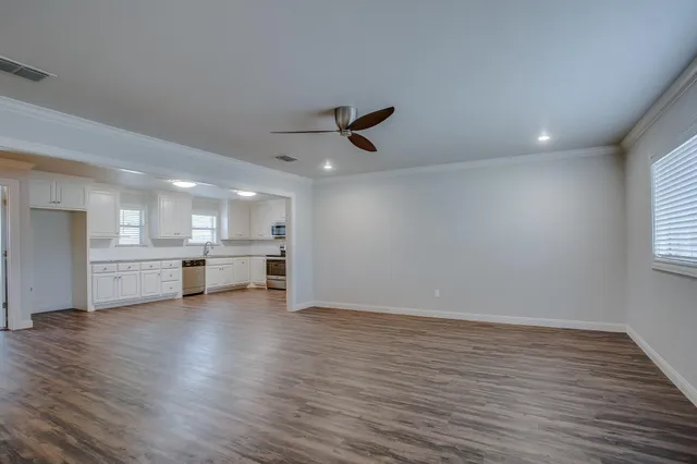 a view of a livingroom with furniture a ceiling fan and wooden floor
