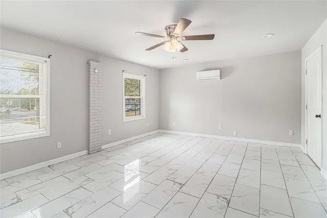 an empty room with windows and fan