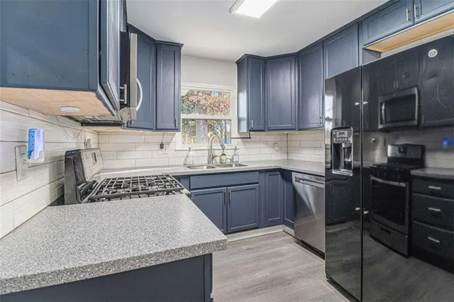 a kitchen with a stove a sink and a microwave