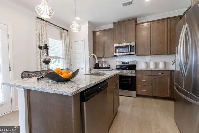 a kitchen with stainless steel appliances granite countertop a sink stove and refrigerator