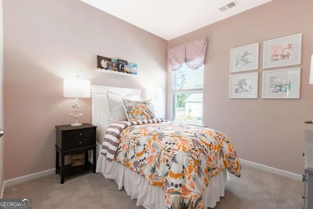 a bed sitting in a bedroom next to a window