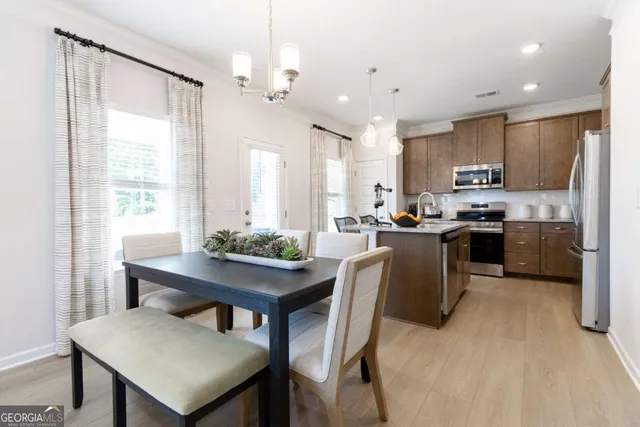 a kitchen with kitchen island a table and chairs in it