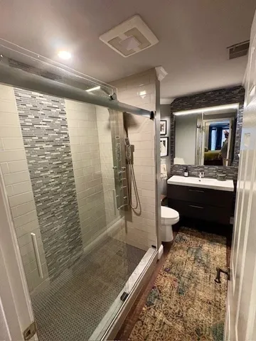 a bathroom with a sink a toilet and shower