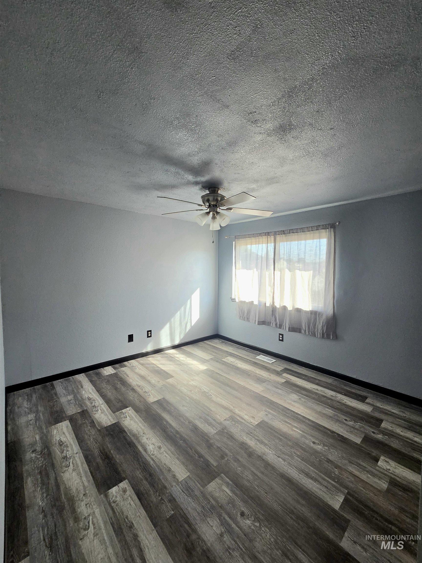 8586 West Rifleman Street Boise, ID 83704 - Photo 18 of 19 Wood-finish flooring with varied plank widths, overhead ceiling fan with light, and multiple electrical outlets