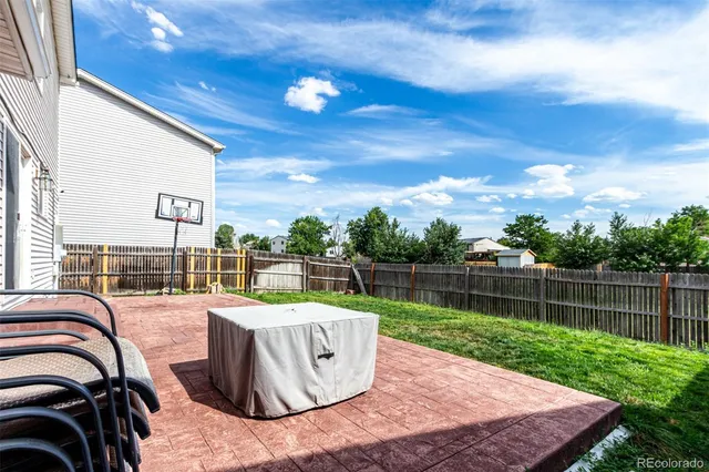 a view of a house with a yard and wooden fence