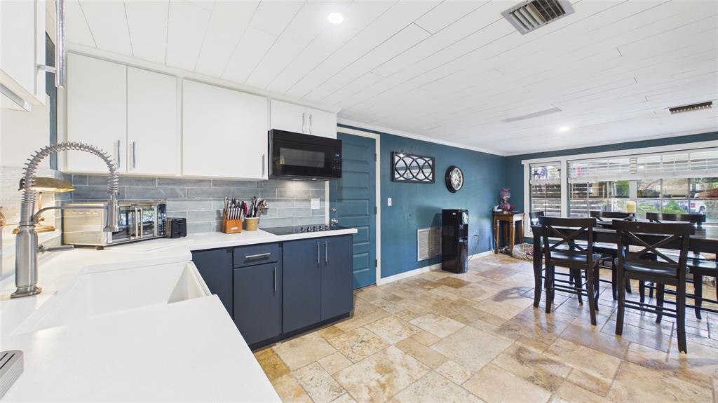 3849 Edgemont Drive New Port Richey, FL 34652 - Photo 19 of 43 a kitchen with stainless steel appliances kitchen island granite countertop a table chairs sink and cabinets