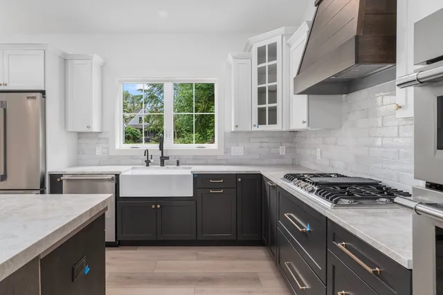 a kitchen with stainless steel appliances granite countertop a sink stove and cabinets