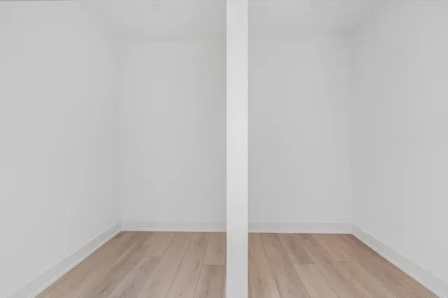 a view of a small space with wooden floor and a window