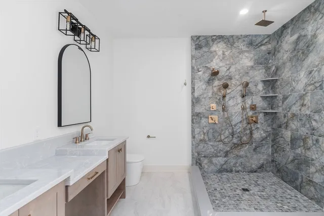 a bathroom with a sink a toilet and shower