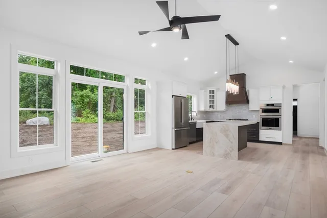 a view of a kitchen with stainless steel appliances wooden floor and a large window