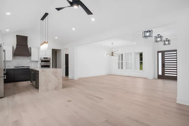 a view of a kitchen with refrigerator and a stove top oven