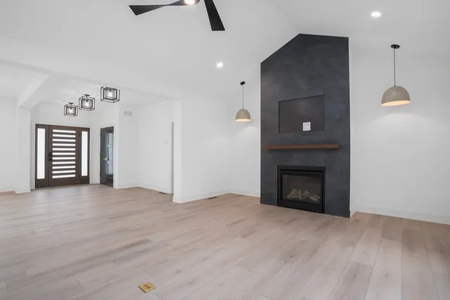 an empty room with windows and fireplace