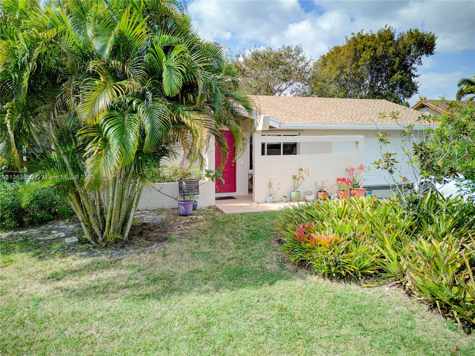 a view of a house with a yard and potted plants