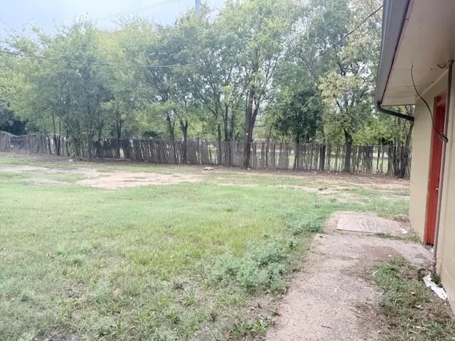 a backyard of a house with lots of green space and fountain