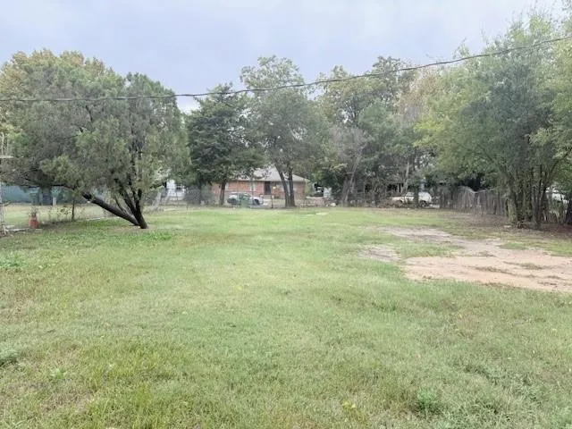 a view of a field with trees in the background