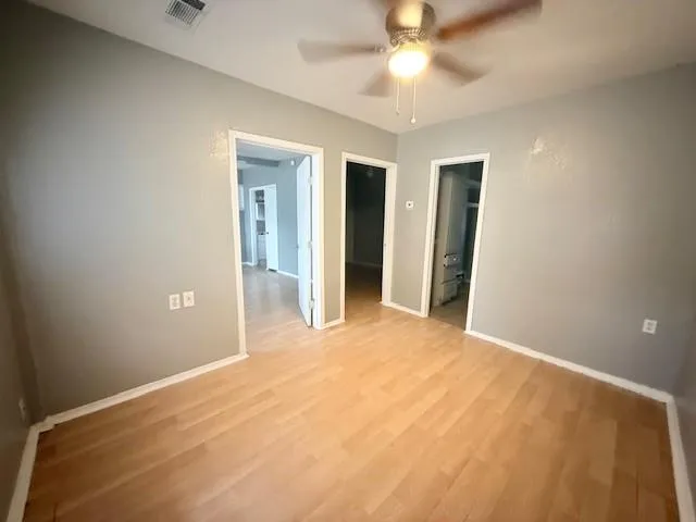 a view of an empty room with a ceiling fan