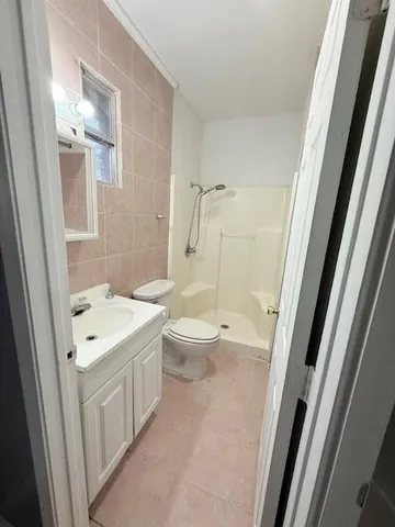 a bathroom with a sink a toilet a mirror and shower