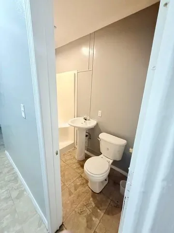 a bathroom with a toilet a sink and a mirror