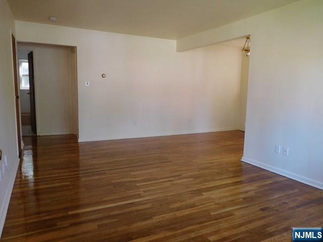 401 West Madison Avenue, Unit 7 Dumont, NJ 07628 - Photo 3 of 10 a view of an empty room with wooden floor and a ceiling fan