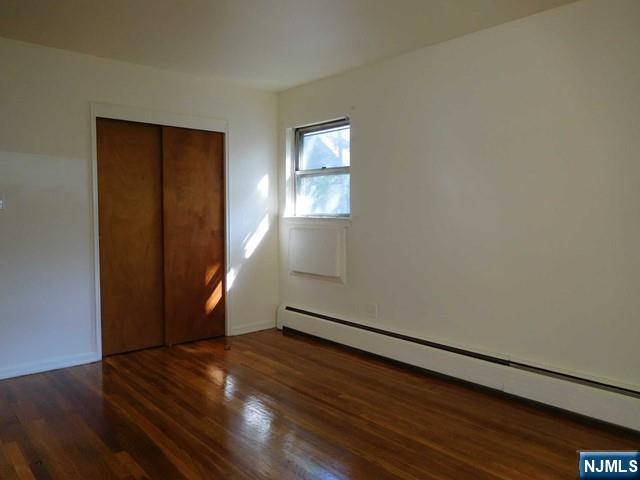 401 West Madison Avenue, Unit 7 Dumont, NJ 07628 - Photo 8 of 10 an empty room with wooden floor and windows