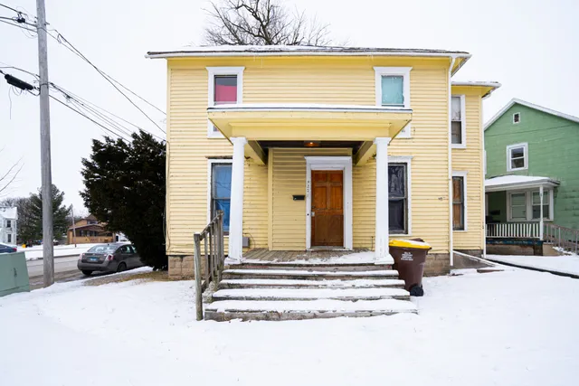 a view of a building with car parked on road