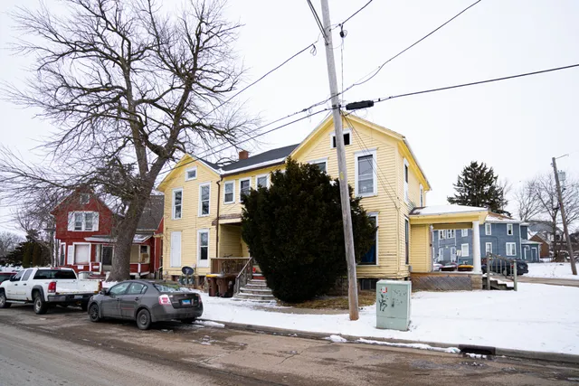a front view of a building with cars parked