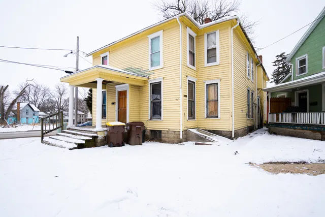 a view of a white house with large windows and a table
