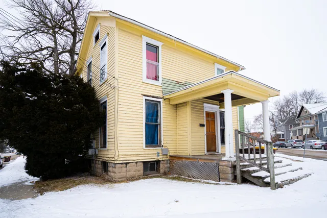 a front view of a house with a tree